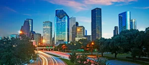 Khung cảnh đô thị hiện đại về đêm với các tòa cao tầng và dòng xe trên cao tốc, minh họa không gian sống đô thị mà thương hiệu Suro hướng tới